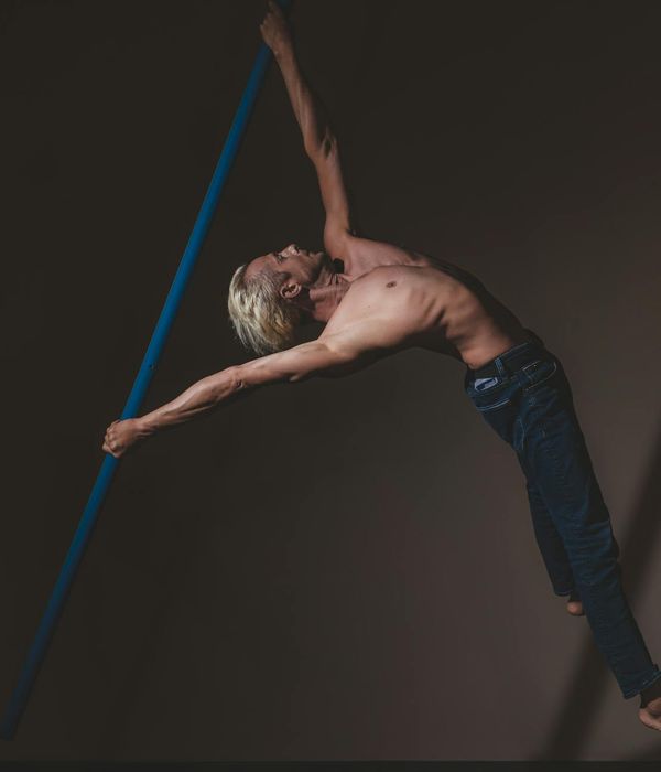 Man performing a controlled strength exercise in a dark room with lime green light.